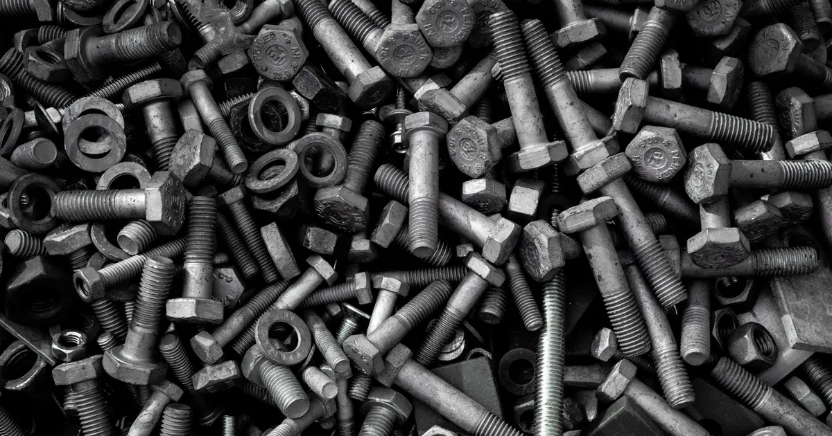 Heap of assorted bolts, nuts and washers in close-up, a generic view of threaded fasteners