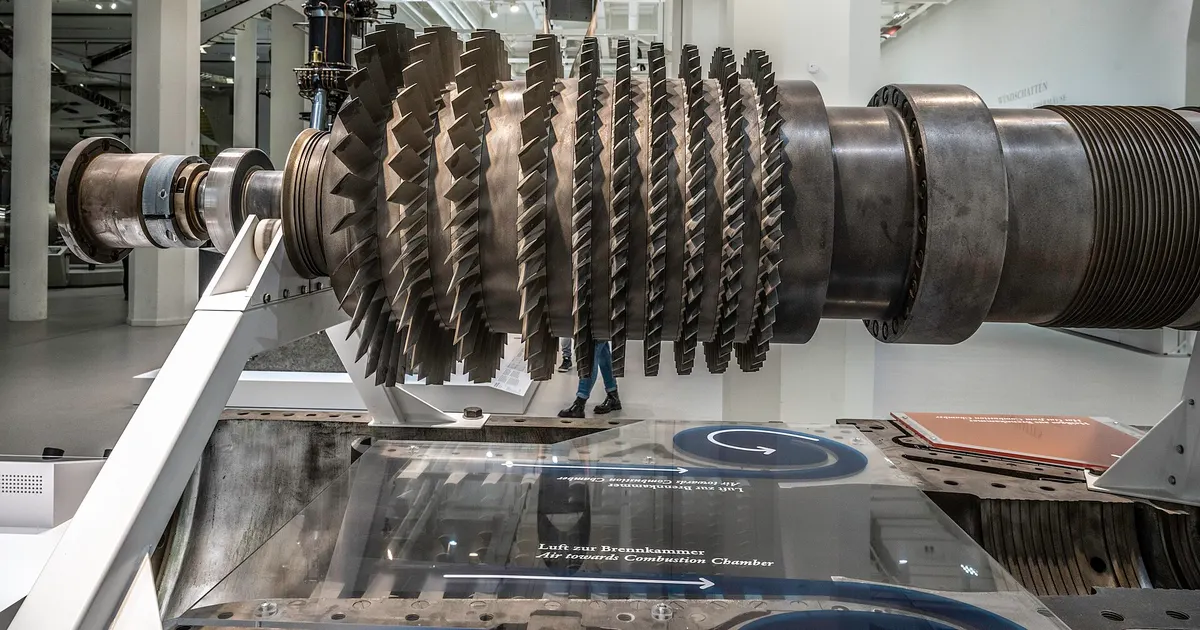 Axial compressor rotor of a gas turbine on display, showing rows of blades mounted on a shaft
