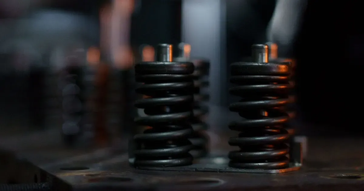 Black coil springs standing on a workshop bench, a generic view of the kind of spring that X-750 and 718 are chosen for